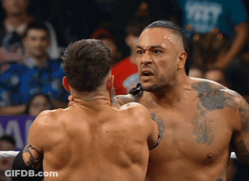 Two Men Are Wrestling In A Ring And One Of Them Has A Tattoo On His Arm GIF