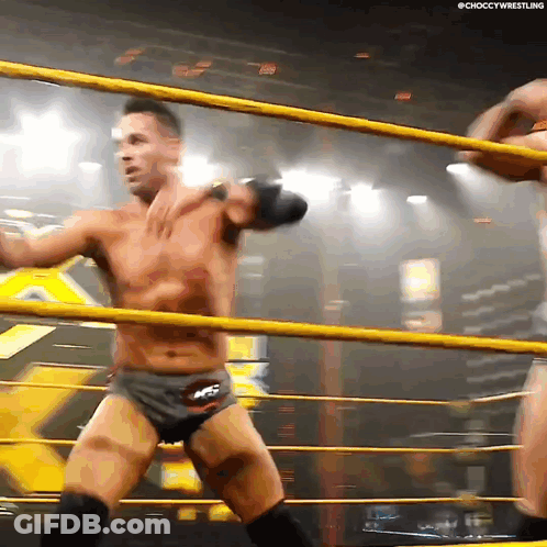 Two Men Are Wrestling In A Ring And One Of Them Is Wearing Shorts That Say Ncs GIF