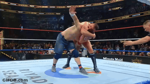 Two Men Are Wrestling In A Ring With A Minute Maid Advertisement On The Side GIF