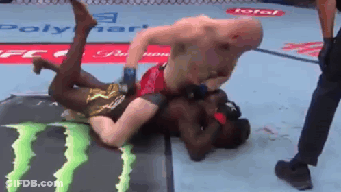Two Men Are Wrestling In A Ring With A Monster Energy Logo On The Floor GIF