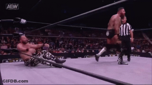 Two Men Are Wrestling In A Ring With A Referee And A Sign That Says Aew On It GIF