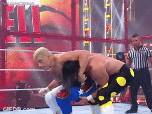 Two Men Are Wrestling In A Ring With A Referee In Front Of A Sign That Says ' Smackdown ' GIF