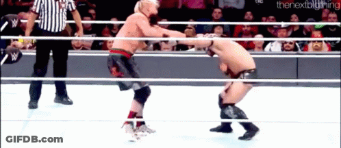 Two Men Are Wrestling In A Ring With A Referee In The Background . GIF