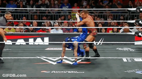 Two Men Are Wrestling In A Ring With A Sign That Says Bajai On It GIF