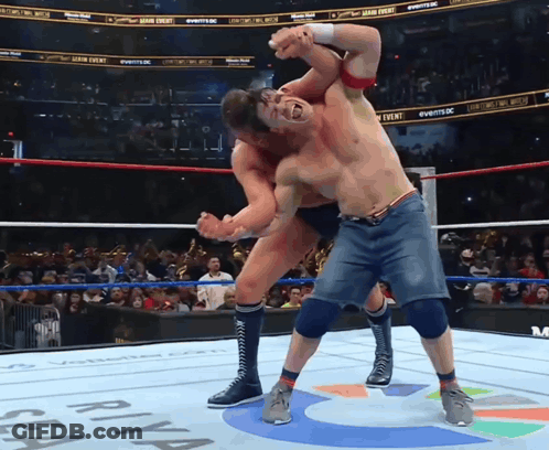 Two Men Are Wrestling In A Ring With A Sign That Says ' Sea ' On It GIF