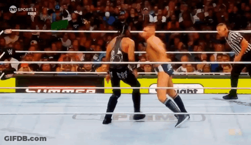 Two Men Are Wrestling In A Ring With A Sign That Says Tnt Sports GIF