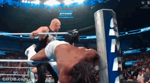 Two Men Are Wrestling In A Ring With A Sign That Says WWE GIF