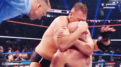 Two Men Are Wrestling In A Ring With Peacock On The Bottom Right GIF