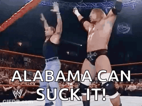 Two Men Are Wrestling In A Ring With The Words Alabama Can Suck It On The Bottom . GIF