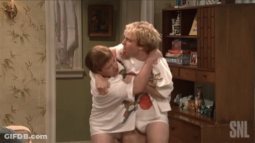Two Men Are Wrestling In A Room With Snl Written On The Bottom Right GIF