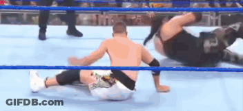 Two Men Are Wrestling In A Wrestling Ring And One Is Laying On The Ground . GIF
