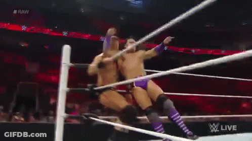 Two Men Are Wrestling In A Wrestling Ring And One Of Them Is Holding A Rope . GIF
