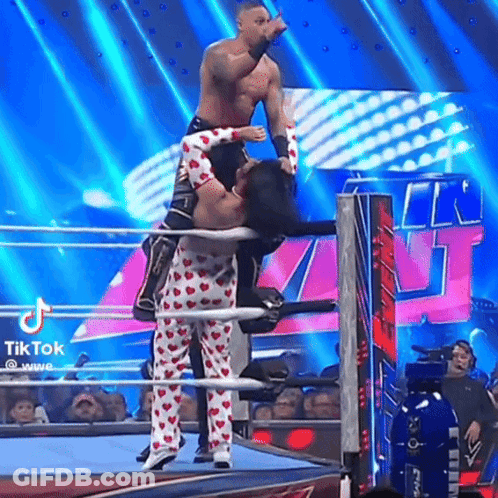 Two Men Are Wrestling In A Wrestling Ring And One Of Them Is Wearing Heart Shaped Pajamas . GIF