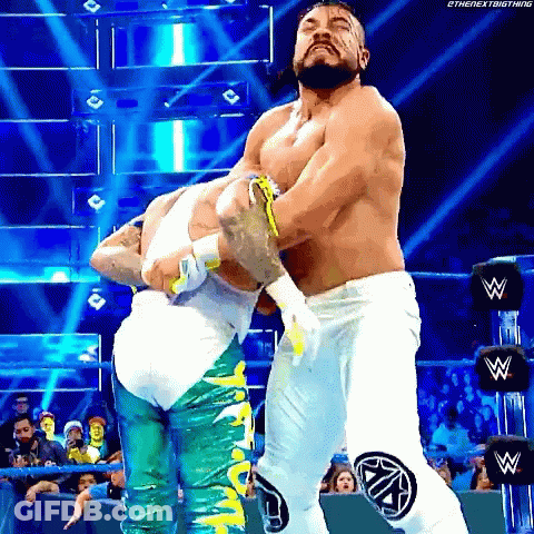 Two Men Are Wrestling In A Wrestling Ring And One Of Them Is Wearing White Pants GIF