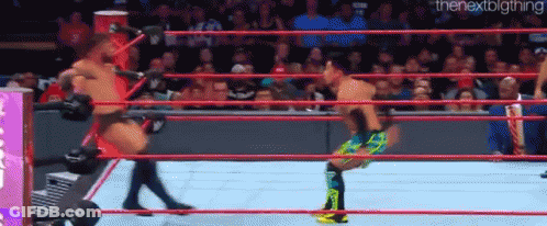 Two Men Are Wrestling In A Wrestling Ring . GIF