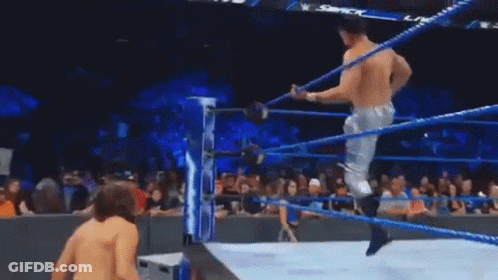 Two Men Are Wrestling In A Wrestling Ring With A Crowd Watching GIF