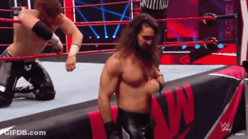Two Men Are Wrestling In A Wrestling Ring With A Sign That Says W On It GIF