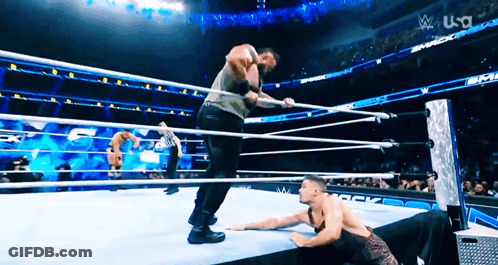 Two Men Are Wrestling In A Wrestling Ring With A Us A Logo In The Background GIF