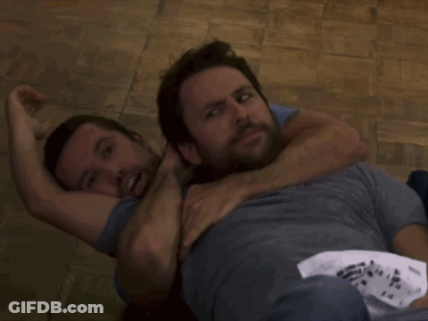 Two Men Are Wrestling On A Wooden Floor And One Of Them Has A Shirt That Says Ninja GIF