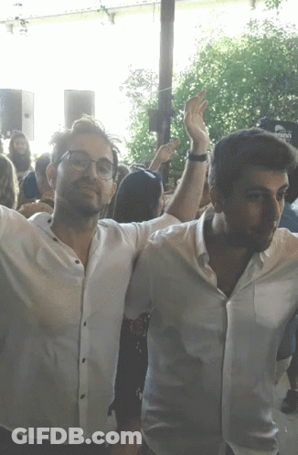 Two Men Arms Outstretched In Crowd With Corona Sign GIF