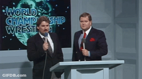 Two Men At Podium With World Champion Wrestling Screen GIF