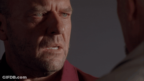 Two Men At Table In Dark Room With Boxes GIF