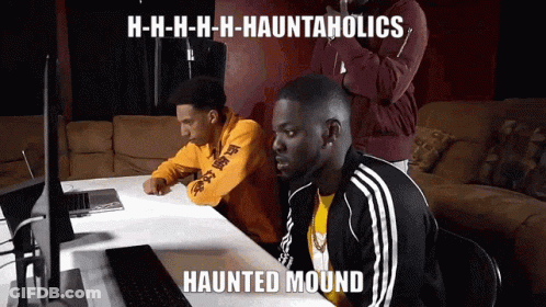 Two Men At Table With Haunted Mound Meme On Laptop GIF