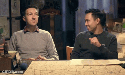 Two Men At Table With Map One Pointing GIF