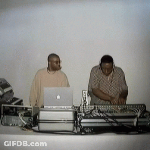 Two Men Behind Table With Apple Laptop GIF