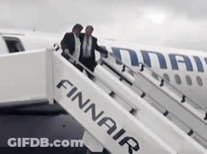 Two Men Boarding Finnair Plane On Cloudy Day GIF
