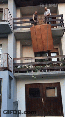 Two Men Carrying Large Furniture GIF