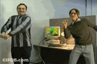 Two Men Dancing In Front Of A Computer Monitor GIF