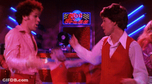 Two Men Dancing In Front Of Bob's Place Neon Sign GIF