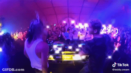 Two Men Dancing In Front Of Crowd At Party With TikTok GIF
