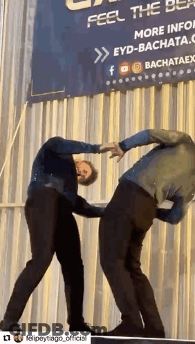 Two Men Dancing In Front Of Feel The Best Sign GIF