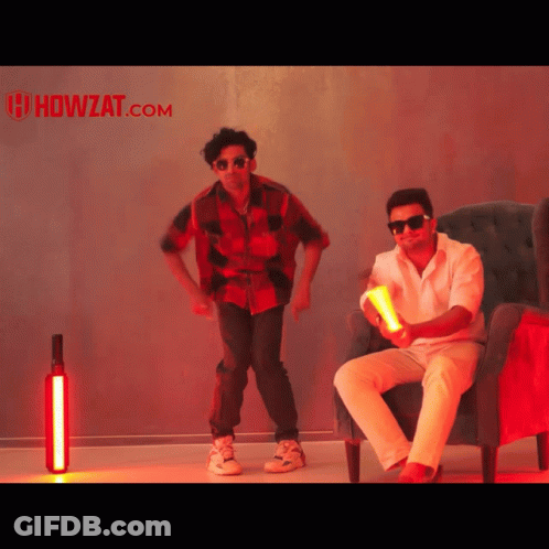 Two Men Dancing In Front Of Howzat.com GIF