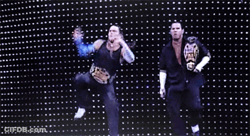 Two Men Dancing In Front Of Lights With WWE Belt GIF