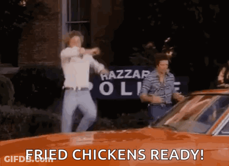 Two Men Dancing In Front Of Orange Car Saying Fried Chickens Ready GIF