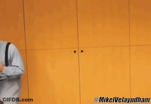 Two Men Dancing In Front Of Yellow Wall GIF