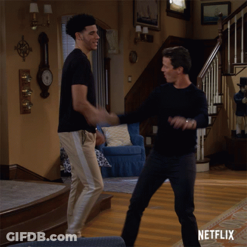 Two Men Dancing In Living Room With Netflix Logo GIF