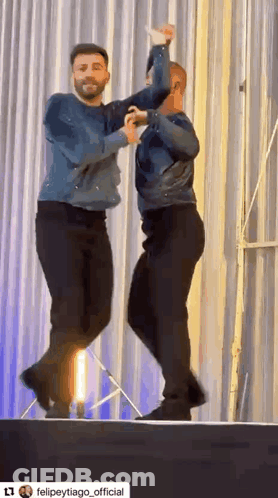 Two Men Dancing On Stage GIF