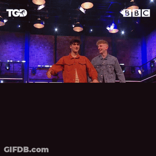 Two Men Dancing On Stage In Front Of BBC Screen GIF