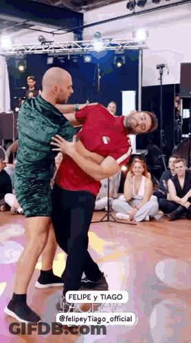 Two Men Dancing, One In Green Dress GIF