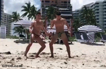 Two Men Dancing Shirtless On Beach GIF