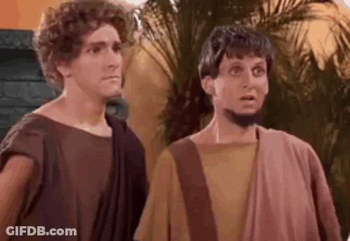 Two Men Dressed As Roman Soldiers Are Standing Next To Each Other And Making Funny Faces . GIF