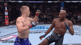 Two Men Fighting In Boxing Ring, One In UFC Shorts GIF