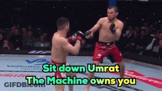 Two Men Fighting In Boxing Ring Saying Sit Down Umrat The Machine Owns You GIF