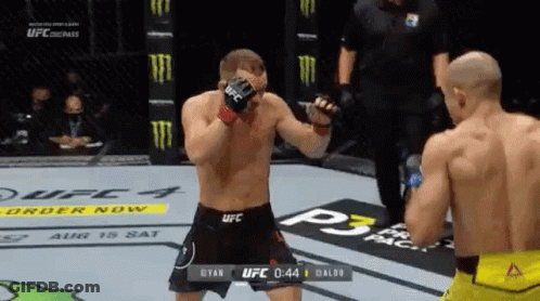 Two Men Fighting In Boxing Ring With Referee GIF