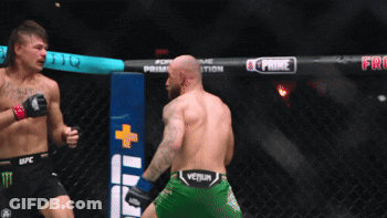Two Men Fighting In Cage With Green Venum Shorts GIF