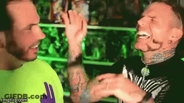 Two Men High-Fiving In Front Of Green Light GIF